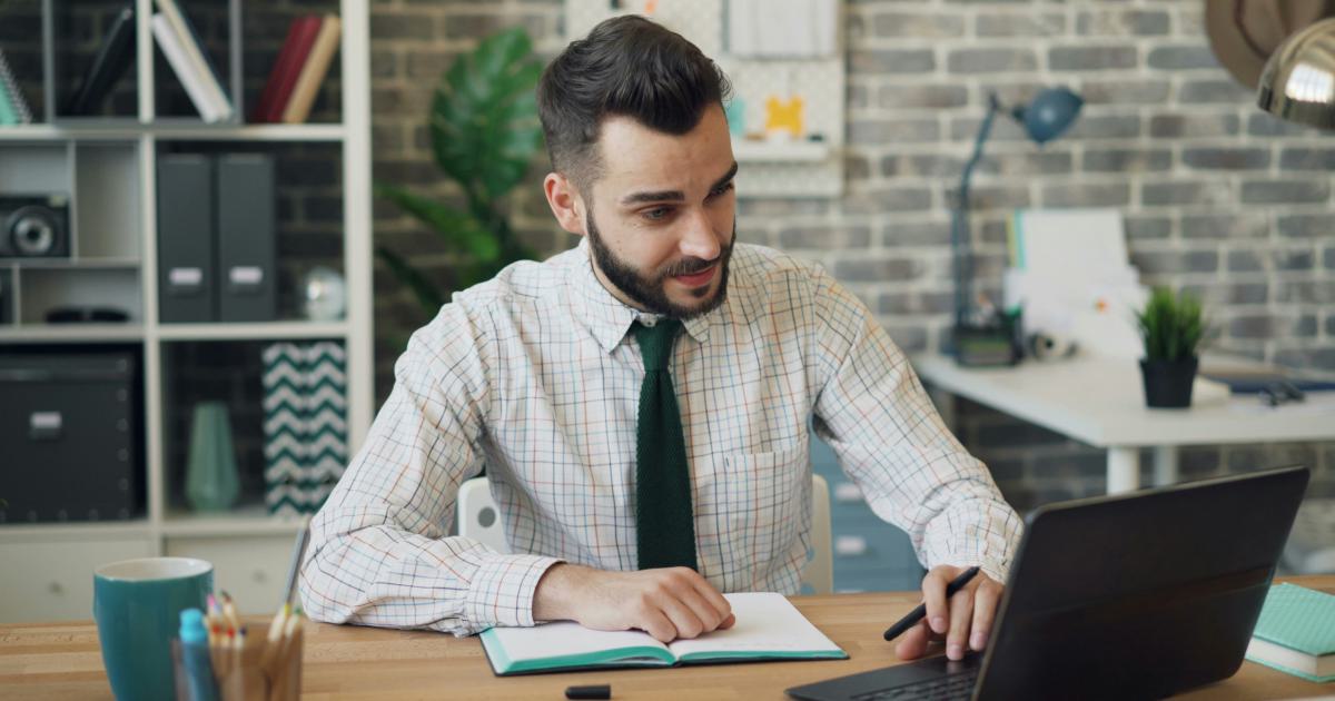 Person Writing on a Laptop